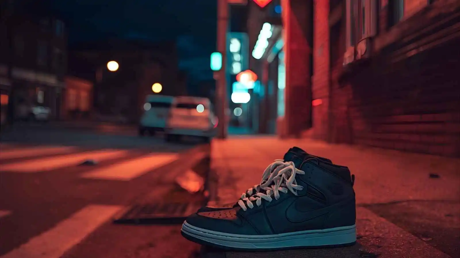 Flatlay of sneakers, heels and boots on a concrete floor in soft natural light.