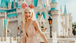 Friends in Mickey ears taking a selfie in front of a Disney-style castle on a sunny day.